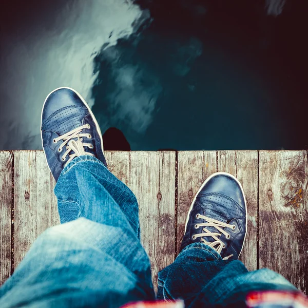 Man op de pier neemt een stap in het water — Stockfoto