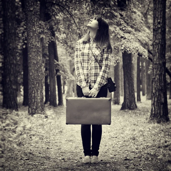 Chica con la maleta vintage y la cámara de pie en el bosque y el baño — Foto de Stock