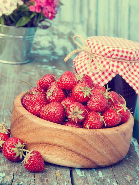 Strawberries in wooden bowl and jam — Stock Photo, Image