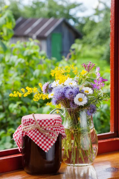 Bunch of garden flowers and jam — Stock Photo, Image