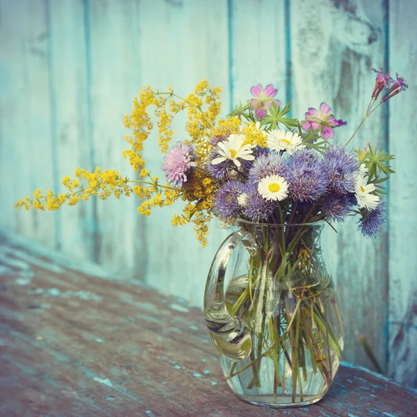 Bouquet di fiori da giardino ed erbe curative in brocca di vetro su vecchi — Foto Stock