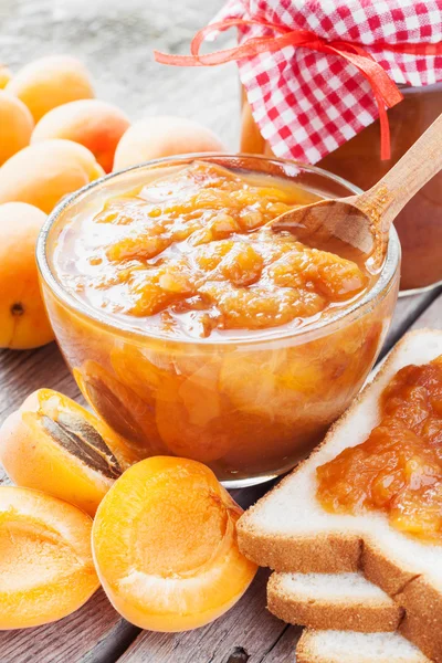 Abrikoos fruit en potje jam op tafel — Stockfoto