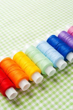 row of thread spools in rainbow colors clipart