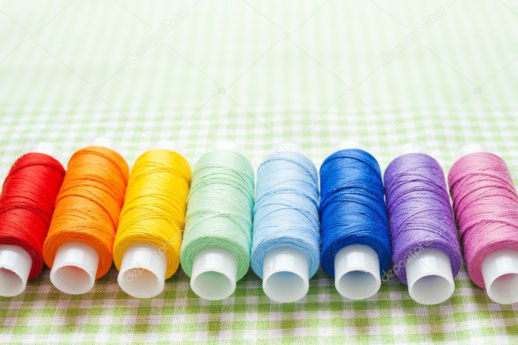 row of thread spools in rainbow colors