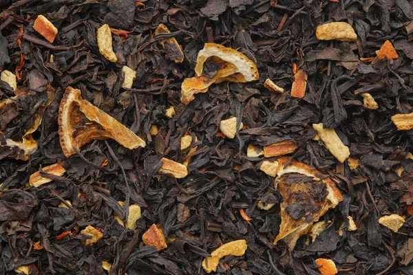 Achtergrond Van Aromatische Zwarte Theebladeren Met Gedroogde Citrusschijfjes Schil Droge — Stockfoto