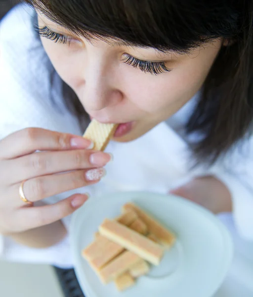 Yakın çekim portre tatlı waffle yemeyi genç kadınların — Stok fotoğraf