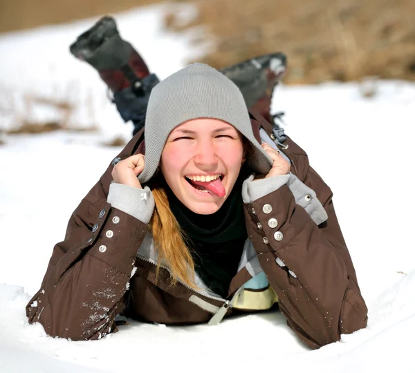 Close-up portrait of smiling young woman lying on a snow indicat — Stock Photo, Image