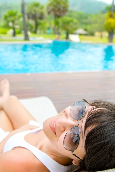 Close-up portrait of young smiling woman with a sunglasses lying — Stock Photo, Image