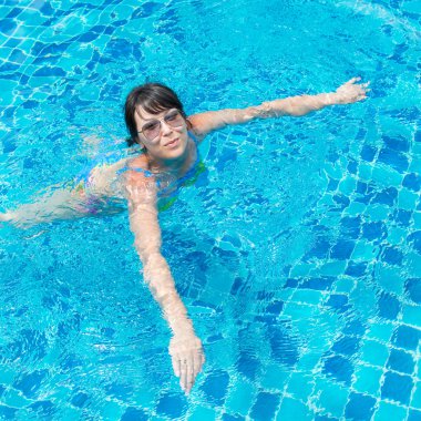 güzel genç kız Havuzda yüzen güneş gözlüğü