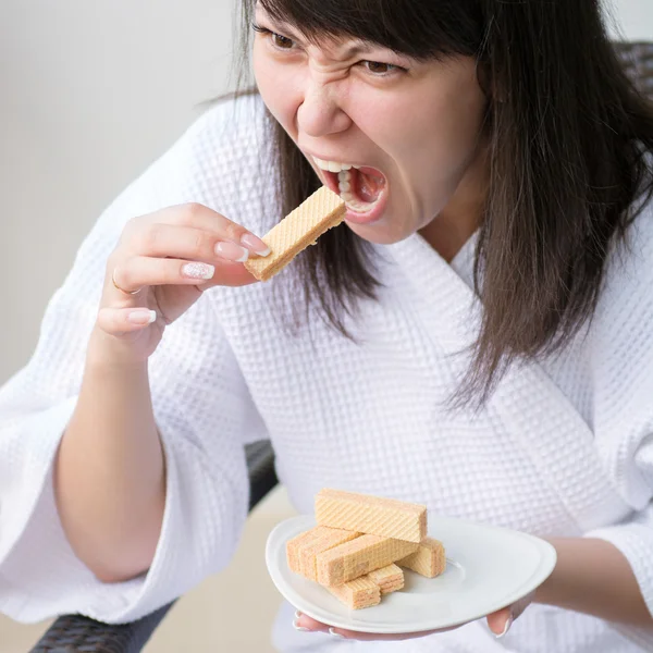 Primo piano Ritratto di giovane bella donna con rabbia mangia wafer, s — Foto Stock