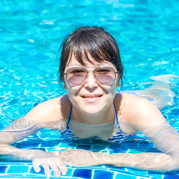 Retrato de uma bela jovem em óculos de sol flutuando no — Fotografia de Stock