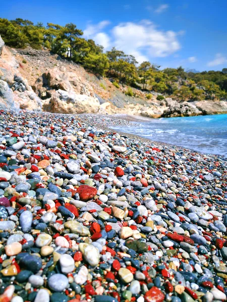 Μια Βοτσαλωτή Παραλία Χρωματιστά Στρογγυλά Βότσαλα Ημέρα Θάλασσα Surf Πεύκα — Φωτογραφία Αρχείου