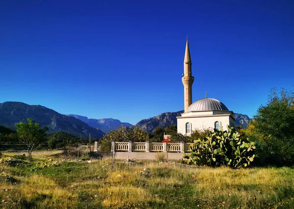 Kırsal bir beyaz cami, bir minare, küçük, mavi gökyüzü, dağlar, yeşillik, boşluk 