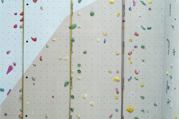 Climbing wall background with ropes and holds. — Stock Photo, Image