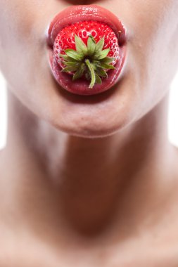 Young woman biting strawberry isolated on white