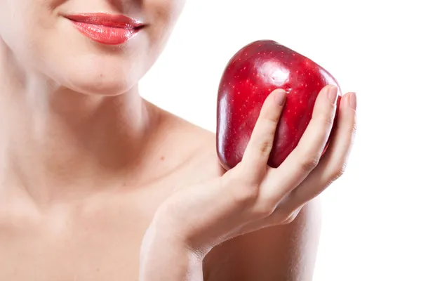 Retrato de una mujer sonriente sosteniendo manzana roja aislada en blanco — Foto de Stock