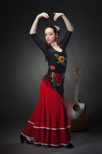 Young woman dancing flamenco with castanets on black — Stock Photo, Image