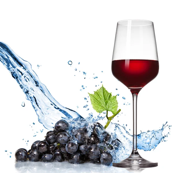 Склянка вина з синім виноградом і бризкою води ізольована на білому — стокове фото