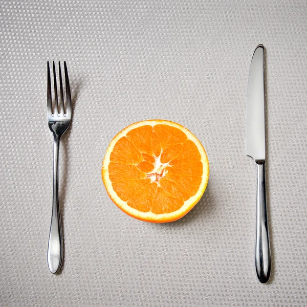 Desayuno saludable - naranja fresca con cuchillo y tenedor — Foto de Stock