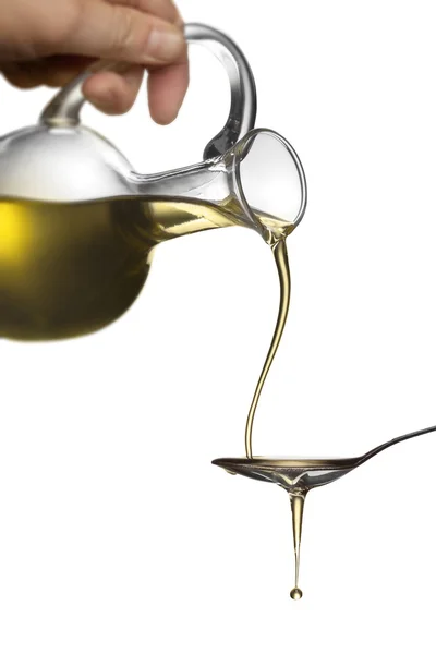 Verter el aceite del frasco sobre la cuchara aislada sobre blanco — Foto de Stock