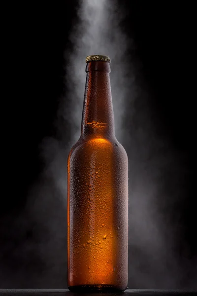 Garrafa de cerveja gelada com gotas, geada e vapor em preto — Fotografia de Stock