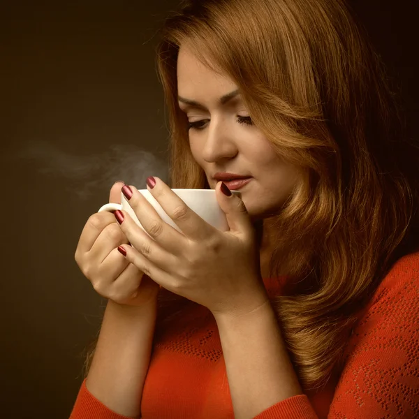 Mujer sosteniendo taza caliente y sonrisas —  Fotos de Stock