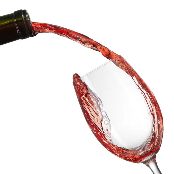 Червоне вино наливається в склянку зі сплеском ізольовано на білому — стокове фото