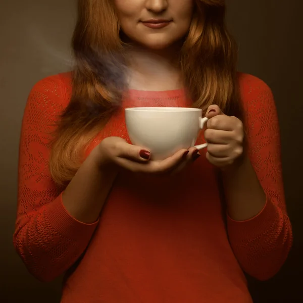 Mujer sosteniendo taza caliente y sonrisas — Foto de Stock