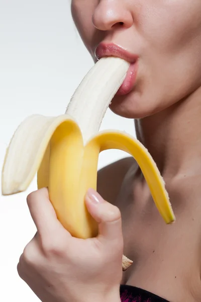 Jeune femme mordant banane isolée sur blanc — Photo