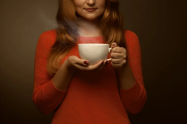 Mujer sosteniendo taza caliente y sonrisas —  Fotos de Stock