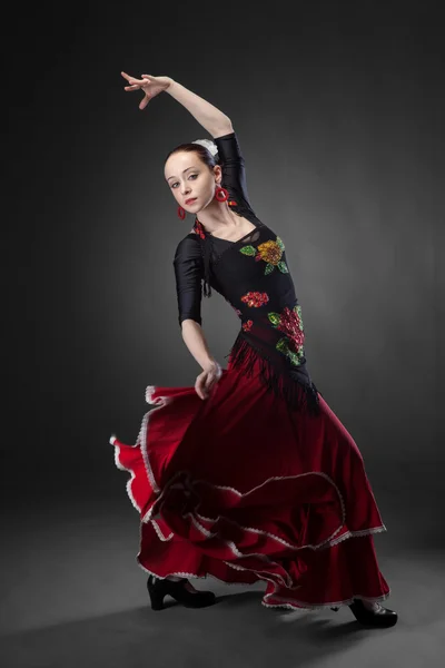 Ung kvinna dansar flamenco på svart — Stockfoto