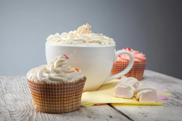 Chocolat chaud avec guimauves, crème et cupcakes sur ba en bois — Photo