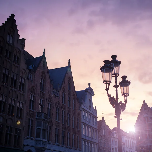 Silhuetas de casas do centro da cidade em Bruges contra a bela su — Fotografia de Stock