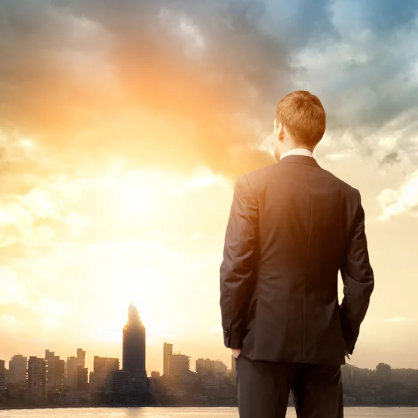 Hombre de negocios mirada amanecer en la ciudad — Foto de Stock