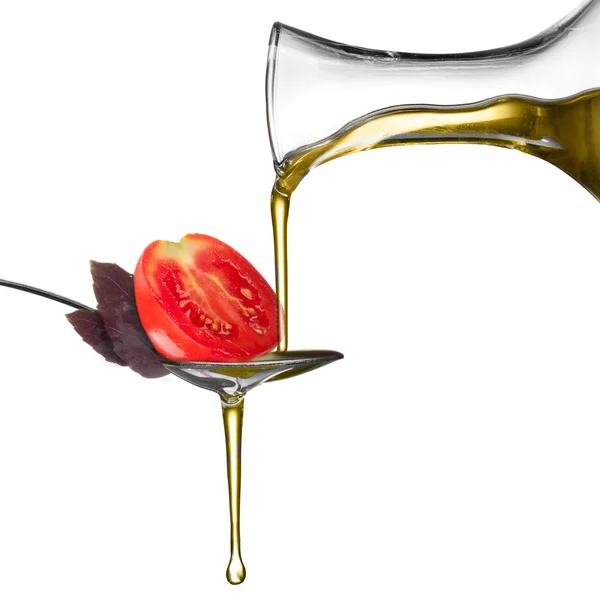 Pouring oil on spoon with basil and tomato isolated on white — Stock Photo, Image