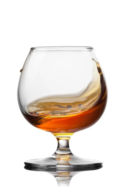 Splash van cognac in glas geïsoleerd op witte achtergrond — Stockfoto