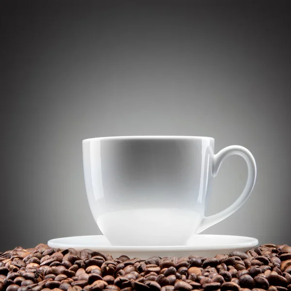 Xícara branca com grãos de café em preto — Fotografia de Stock