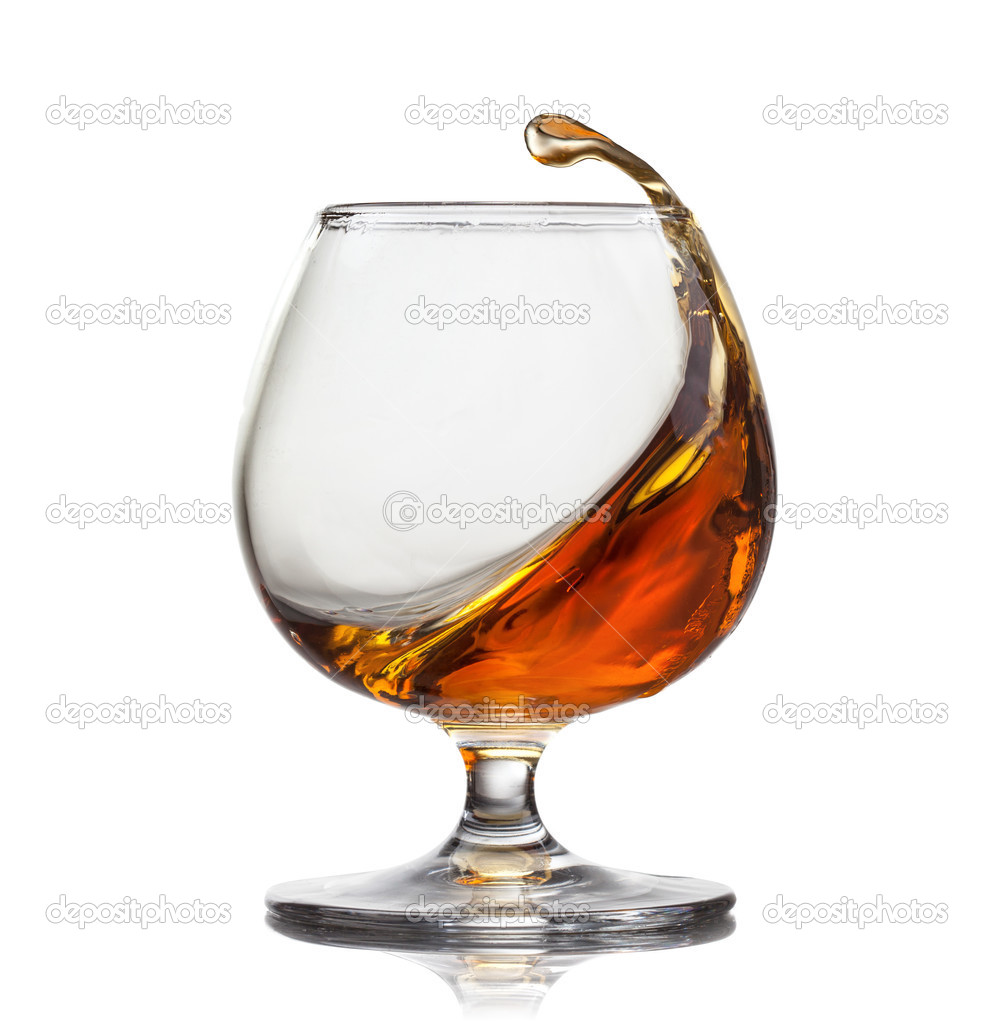 Splash of cognac in glass isolated on white background Stock Photo by