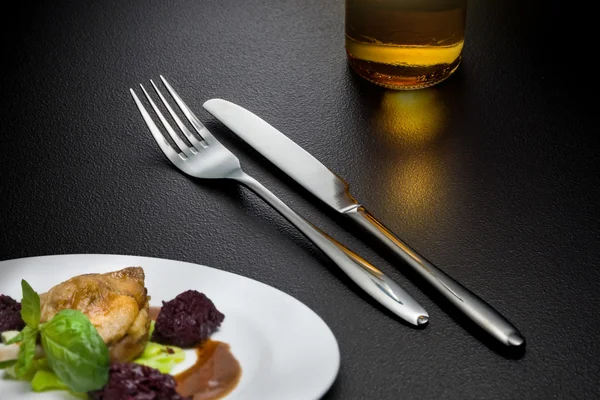 Bottle of beer, knife and fork on table — Stock Photo, Image