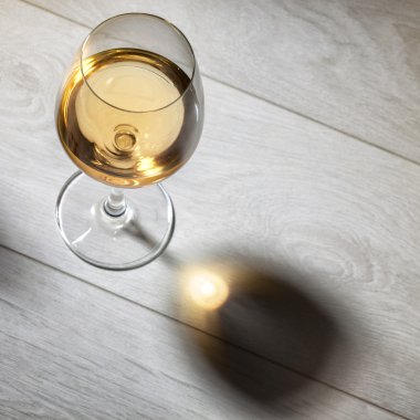 Glass of white wine on wooden table. Top view clipart