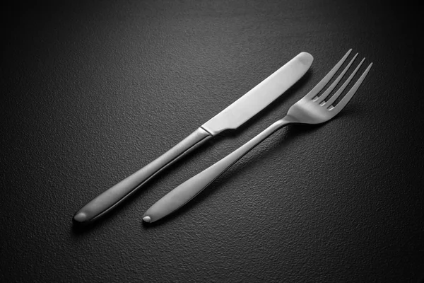Kniv och gaffel på svart — Stockfoto