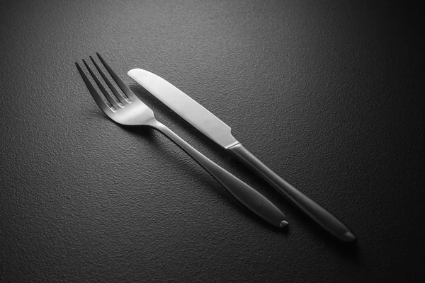 Messer und Gabel auf schwarz — Stockfoto