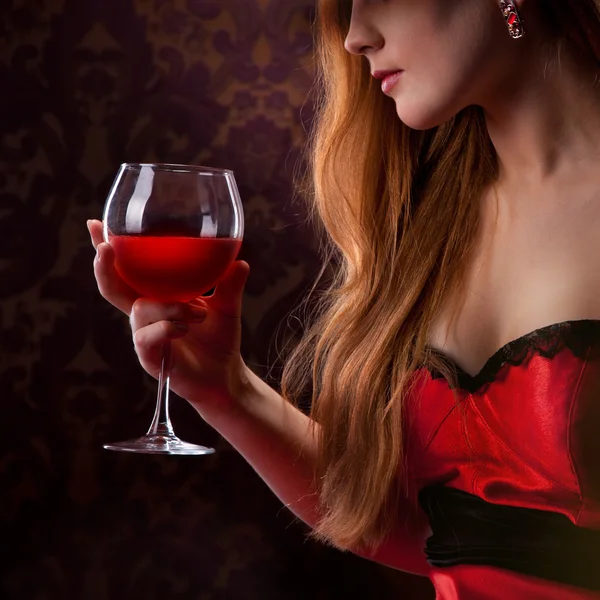 Elegantní žena drží sklenici červeného vína — Stock fotografie