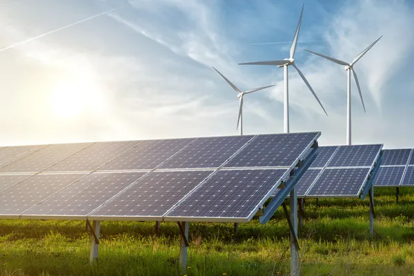 Panneaux solaires et éoliennes sous le ciel bleu au coucher du soleil — Photo