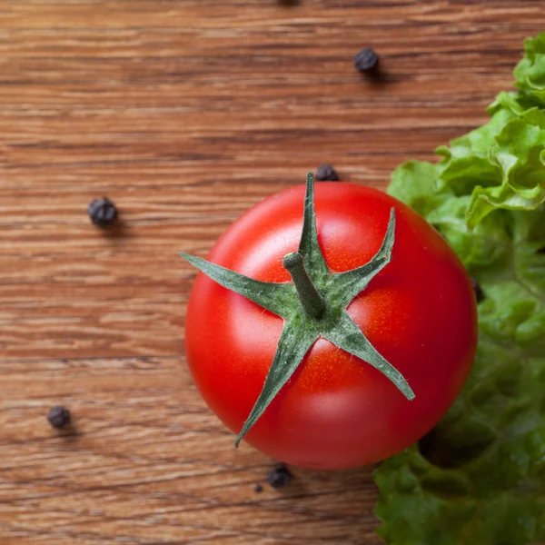 Röd tomat med grönsallad på trä — Stockfoto