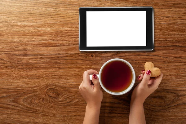 Nő kezében forró csésze tea a cookie-k — Stock Fotó