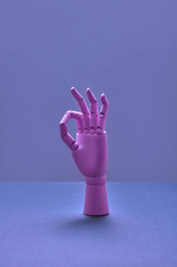 Sanatçı mankeninin dikey tahta eli. Parmakları yerinde. Stüdyoda neon ışığı var.