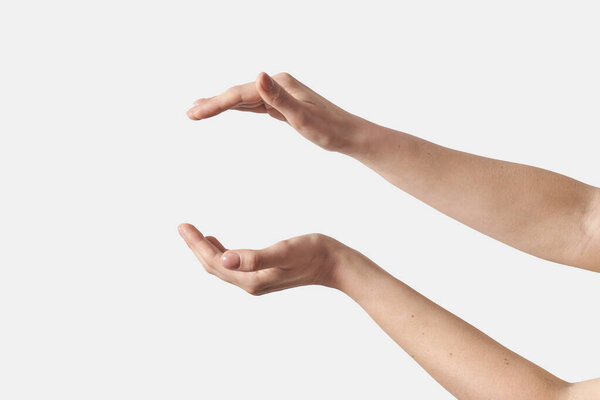 Wide open female hands for your product placement horizontal position isolated on white background. Soft grab action woman hands.