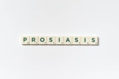 Sedef hastalığı, beyaz arka planda Scrabble blokları oluşturur. Deri hastalığı ve fiziksel sağlık farkındalığı.