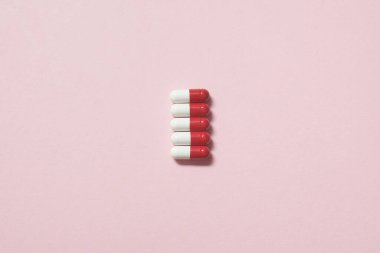 Kırmızı ve beyaz ilaç hapları pembenin üzerine güzelce serilmişti. Fotokopi alanı olan düz bir yer. Sağlık ve ilaç destekli tedavi.